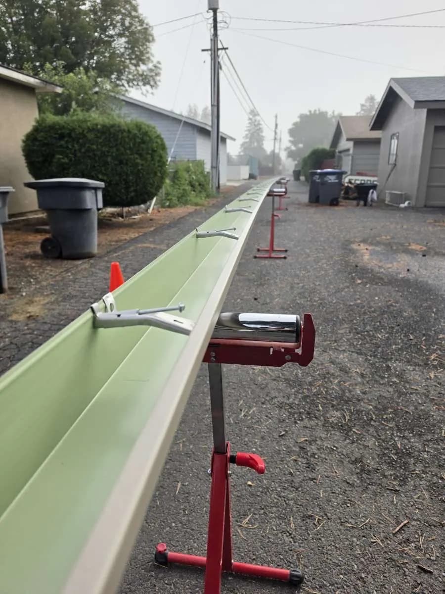 Close-up of a seamless gutter with hidden hangers, formed on-site and resting on a roller stand