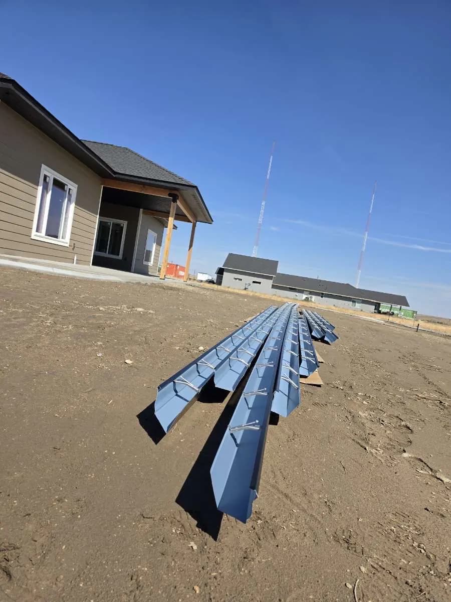 Seamless gutter sections staged at a new-construction home during a free gutter estimate
